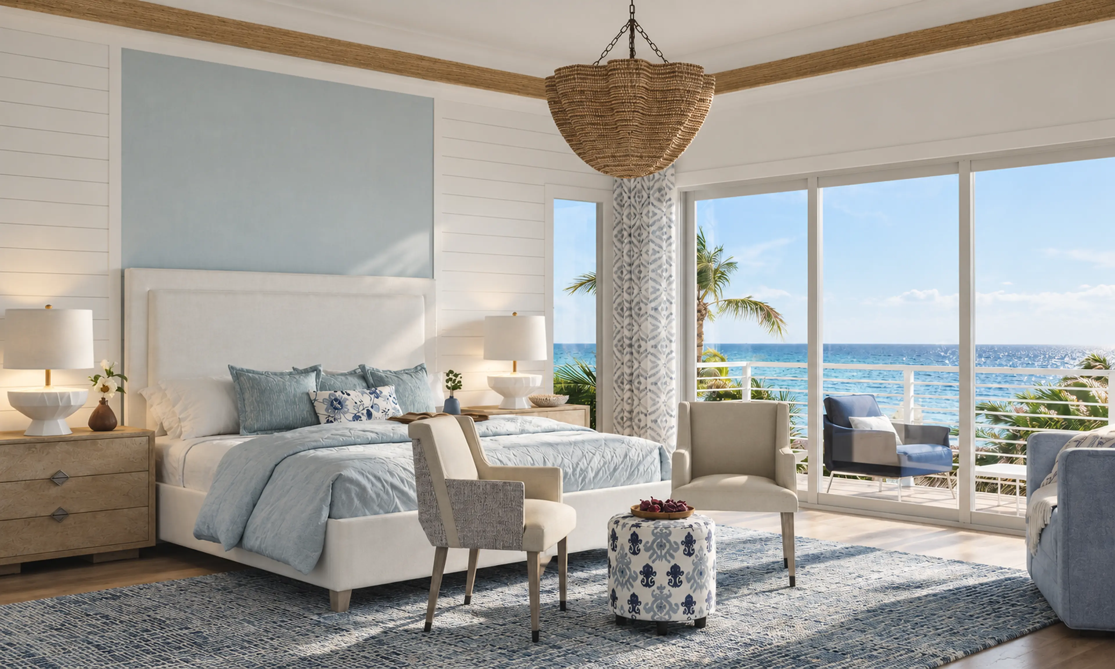 Photographic oceanfront primary bedroom with blue textiles and a woven pendant.