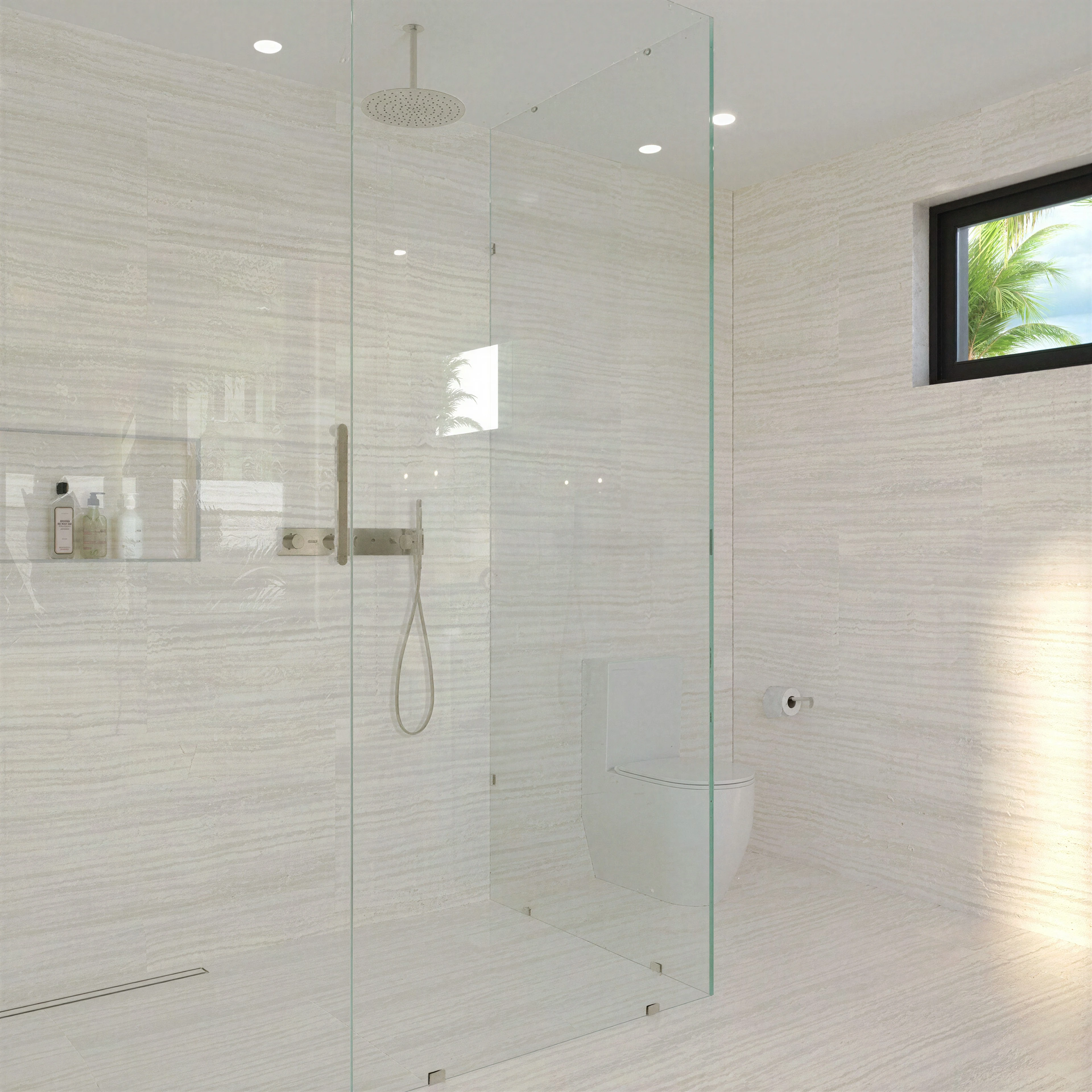 Glass shower enclosure with light tiled walls.