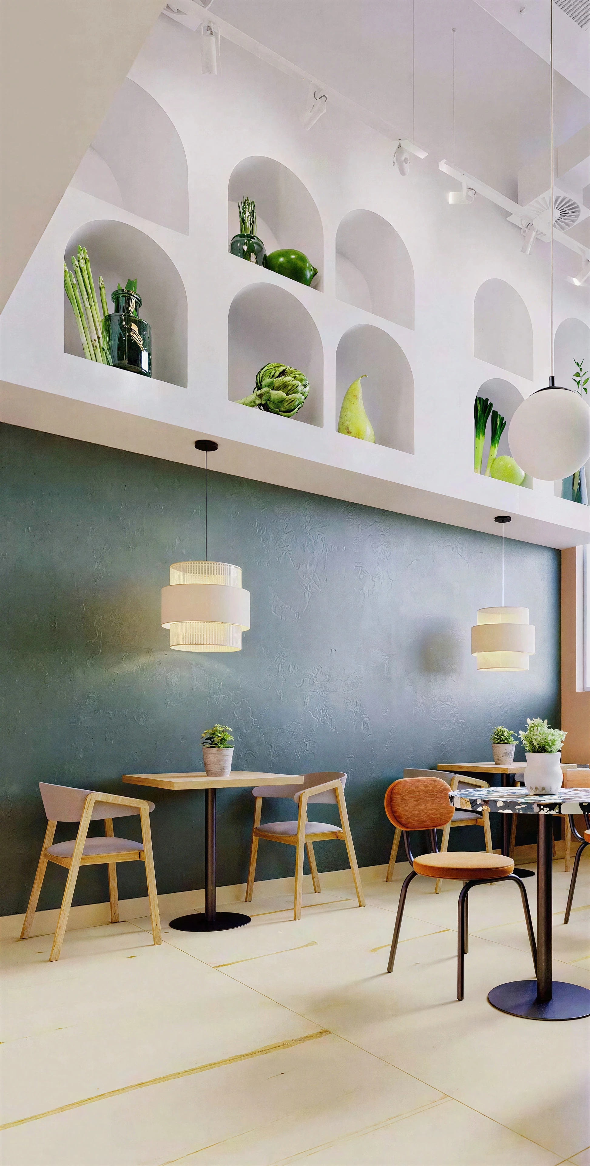 Restaurant seating beneath a tall wall with arched display niches.