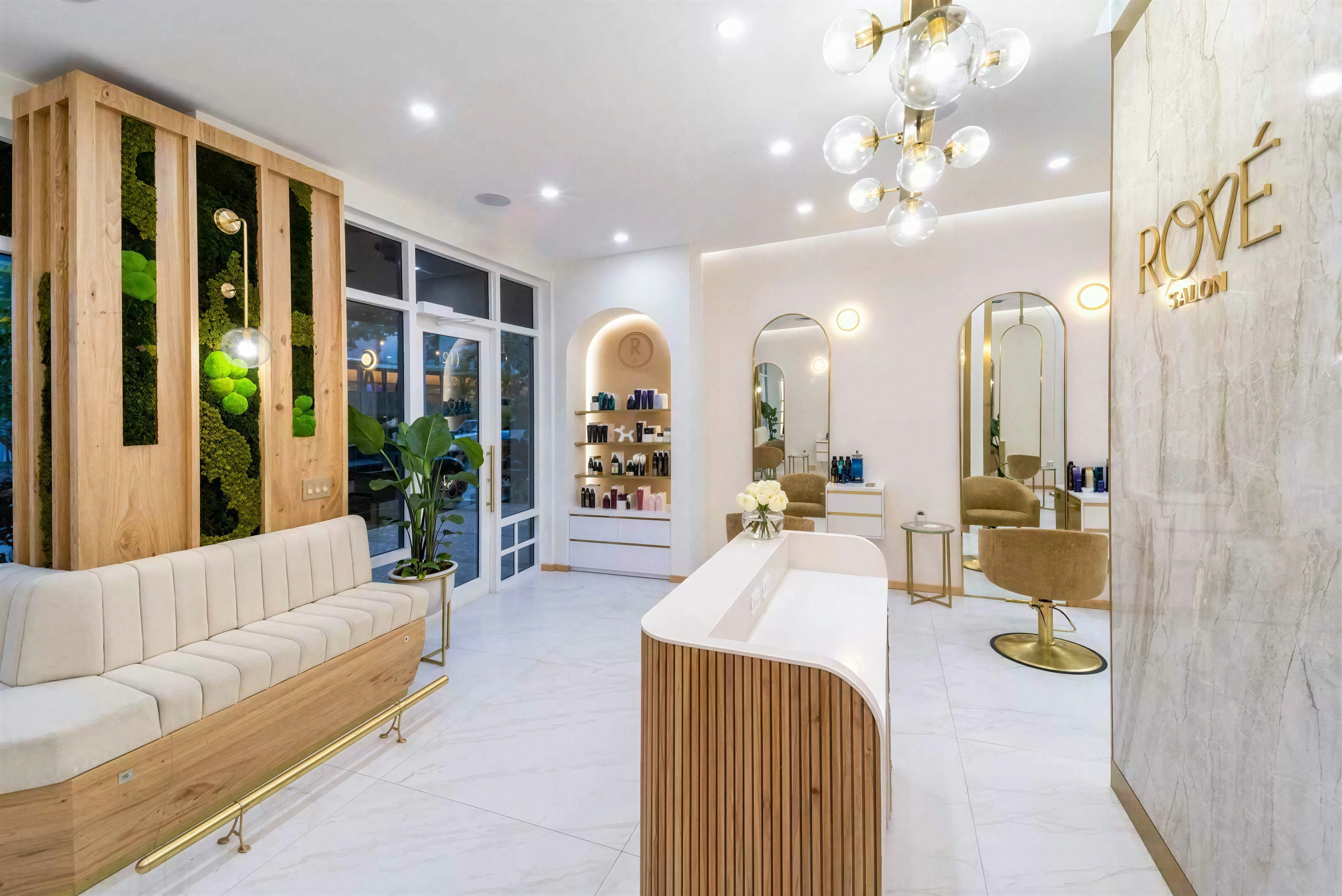 Salon reception with a curved wood desk, stone wall and upholstered bench.
