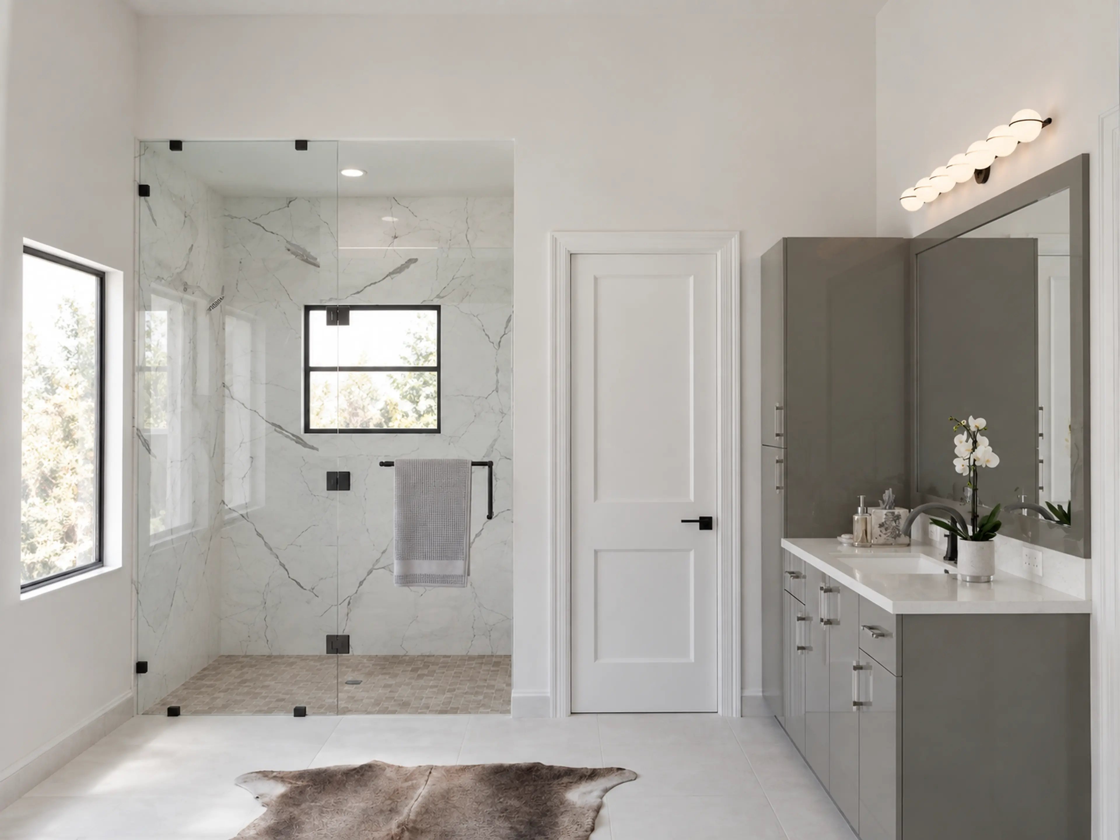 Photographic bathroom with marble shower and a long floating vanity.
